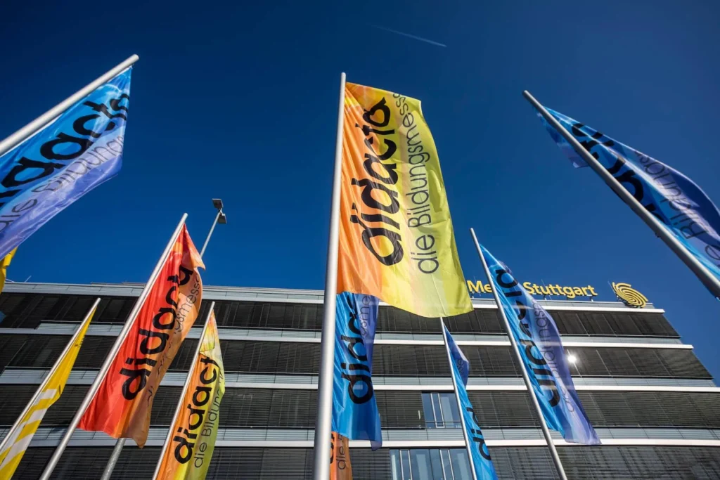 chorus ev - mehrere flaggen mit aufschrift didacta die bildungsmesse vor einem gebaede